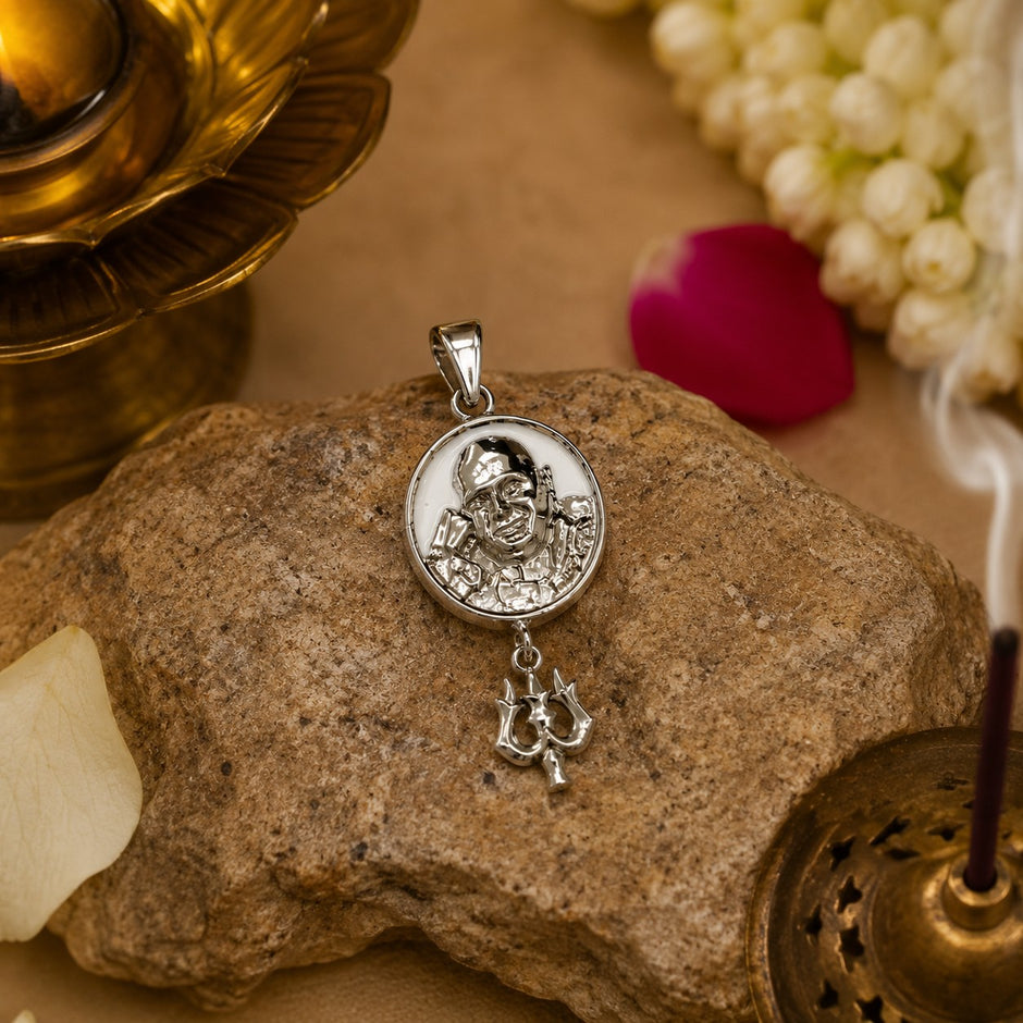My Guru Ji silver-finish brass pendant featuring a portrait of Guru Ji and a trishul charm resting on a stone.